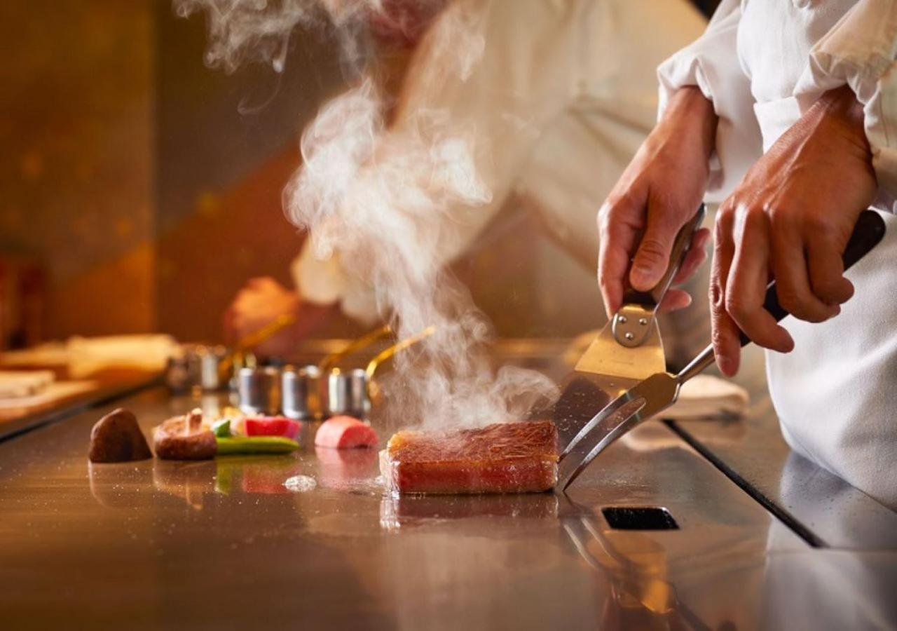Imperial Hotel Tokyo Exterior photo A chef seasoning a steak